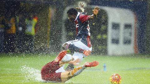 Đội Bologna (áo đỏ/xanh) và Roma trong cơn mưa lớn tại sân vận động Renato dall'ara