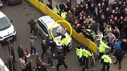 Một CĐV nhảy lên nóc xe ô tô để sẵn sàng đánh nhau với fan của Tottenham