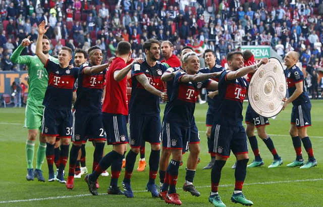 Các cầu thủ Bayern nối đuôi nhau đi giễu hành. Thêm một mùa giải nữa họ lên ngôi mà không gặp bất kỳ trở ngại nào.