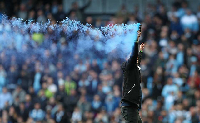 Khói xanh được một fan Man City phun ra tại Etihad. Thành Manchester hiện giờ đã hoàn toàn bị màu xanh che phủ.