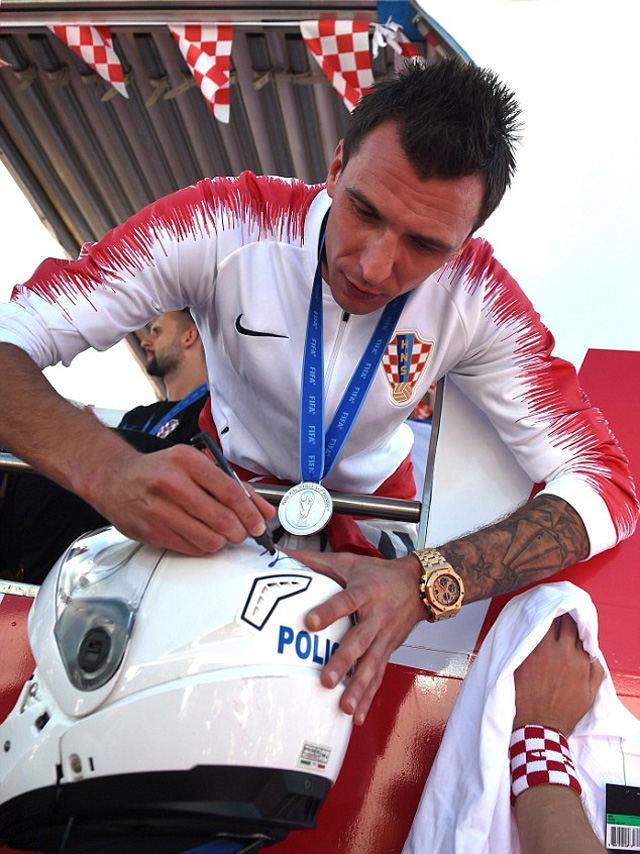 Tiền đạo Mario Mandzukic ký tặng lên chiếc mũ bảo hiểm của cảnh sát trong lễ ăn mừng. Ở trận chung kết, chân sút 32 tuổi là 1 trong 2 cầu thủ ghi bàn cho Croatia trước Pháp.