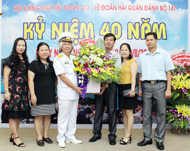 Tổng biên tập báo Bóng đá Nguyễn Văn Phú (thứ ba từ trái sang) - đại diện thế hệ chiến sỹ đầu tiên của Tiểu đoàn 473 - nhận hoa chúc mừng từ Đại tá Nguyễn Quốc Doanh (thứ ba từ phải sang) - Lữ đoàn trưởng Lữ đoàn 147 