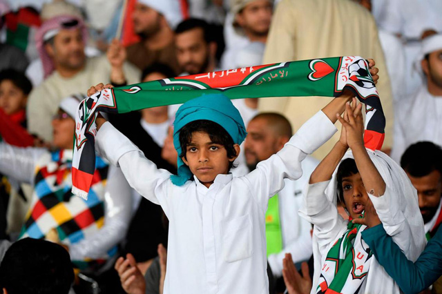 Một cậu bé người Dubai mang theo một chiếc khăn trước trận khai mạc giữa UAE và Bahrain