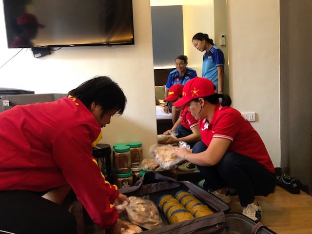 Trợ lý thủ môn Kim Hồng giúp 2 nữ CĐV phân chia các gói thực phẩm. Ảnh: Đức Cường