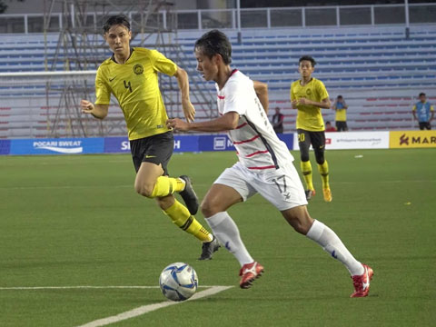 Cầu thủ Malaysia vất vả đeo bám Campuchia trong trận đấu quyết định ở vòng bảng - Ảnh: Đức Cường