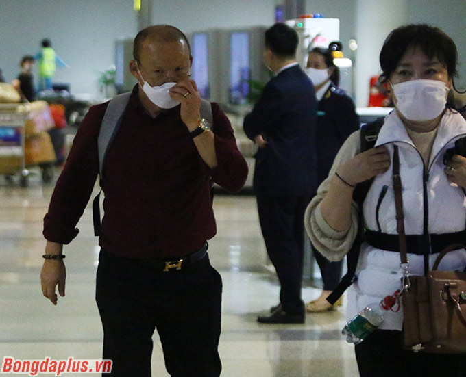 Ông cùng vợ bịt kín khẩu trang, rảo bước rất nhanh rời khỏi sân bay Nội Bài 