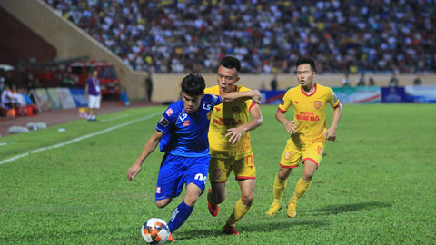 Cầu thủ của Quảng Nam (bìa trái) nỗ lực đi bóng trước các cầu thủ Nam Định	Ảnh: Phan Tùng