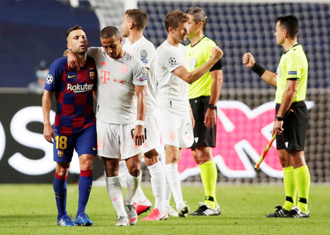 Thiago Alcantara an ủi đồng đội cũ Jordi Alba (bìa trái) sau khi cùng Bayern đánh bại Barca với tỷ số 8-2 rạng sáng qua