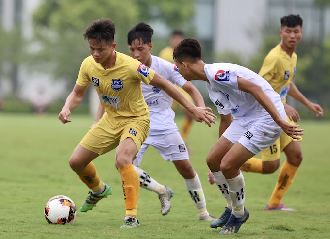 Cầu thủ Thanh Hoá (áo vàng) đi bóng trước sự đeo bám của các cầu thủ Đồng Tháp