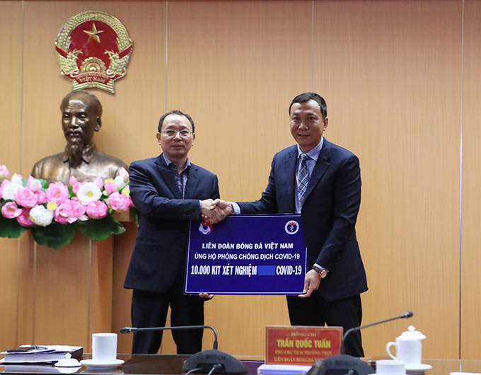 Vụ trưởng Vụ Kế hoạch tài chính Bộ Y tế Nguyễn Nam Liên (bên trái) đại diện Bộ Y tế nhận 10.000 bộ kit xét nghiệm COVID do LĐBĐVN trao tặng - Ảnh: Phan Tùng