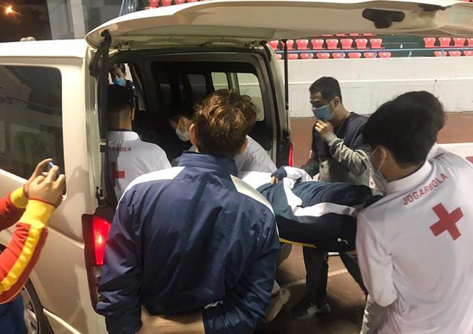 Hậu vệ Anh Việt được đưa lên xe cấp cứu đến bệnh viện. Ảnh: Phan Tùng