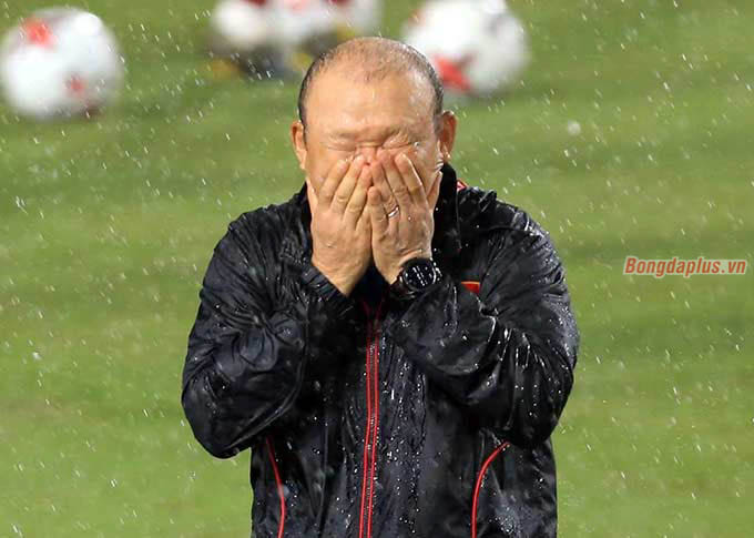 Mưa lớn khiến HLV Park Hang Seo phải bỏ kính. Ông liên tục vuốt mặt khi nước mưa cứ trút xuống sân không ngừng