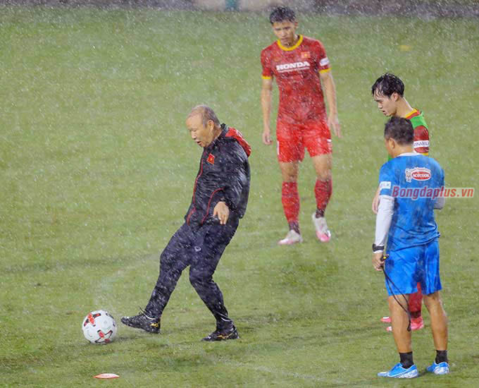 Nhà cầm quân Hàn Quốc cố gắng đá trái bóng thị phạm cho các học trò. Nhưng sân trơn, bóng ướt cộng với mắt nhoè đi vì mưa khiến động tác của ông không được dứt khoát như mong đợi 