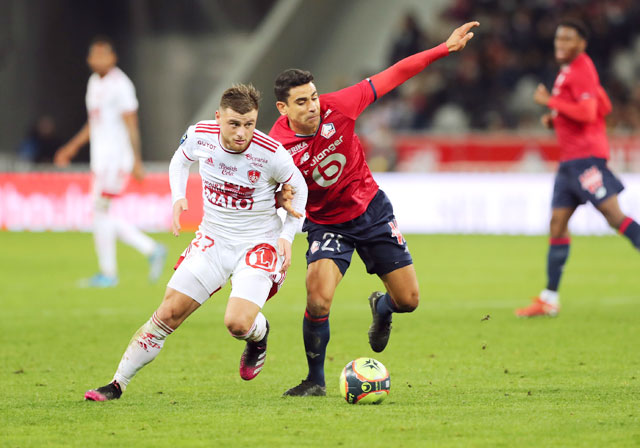 Cầu thủ Lille (phải) chật vật đi bóng trước sự theo kèm của cầu thủ Brest