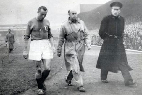 Cầu thủ Italia rời sân Windsor Park dưới sự hộ tống của cảnh sát trong trận đấu vào ngày 4/12/1957