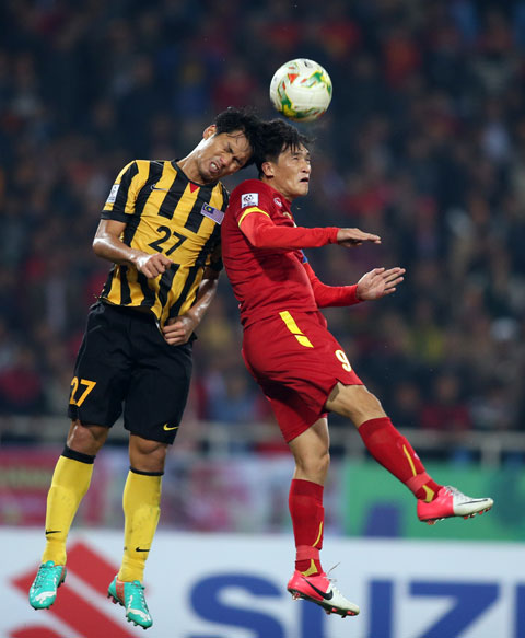 Đội trưởng Công Vinh nỗ lực tranh bóng với cầu thủ Malaysia ở bán kết lượt về tại Mỹ Đình 	Ảnh: Minh Tuấn
