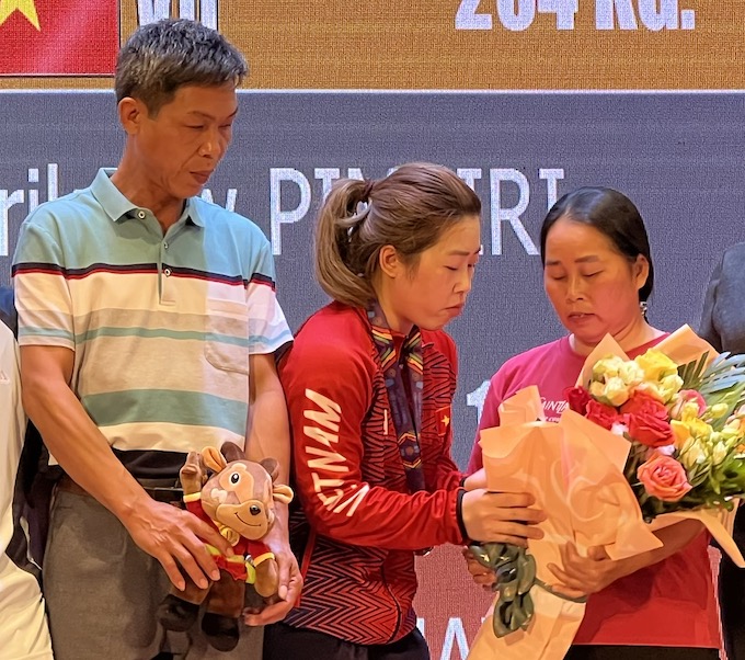 Hoàng Thị Duyên trao bó hoa cho mẹ trên bục nhận huy chương - Ảnh: Tuấn Thành