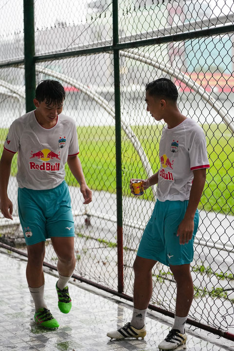 Đôi bạn trẻ trò chuyện, chia sẻ sau giờ tập với đội dưới cơn mưa tại TPHCM