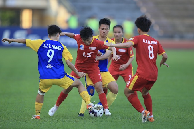 Pha tranh bóng giữa cầu thủ TP.HCM I (đỏ) và Thái Nguyên T&T - Ảnh: Đức Cường