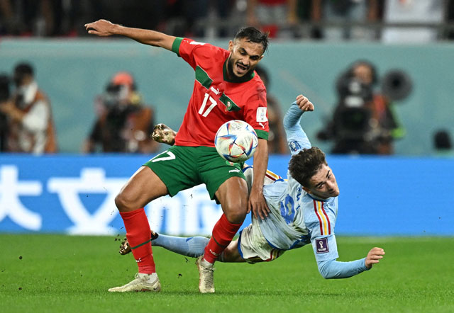 Gavi (phải) thất thế hoàn toàn trong một pha tranh chấp với cầu thủ Morocco