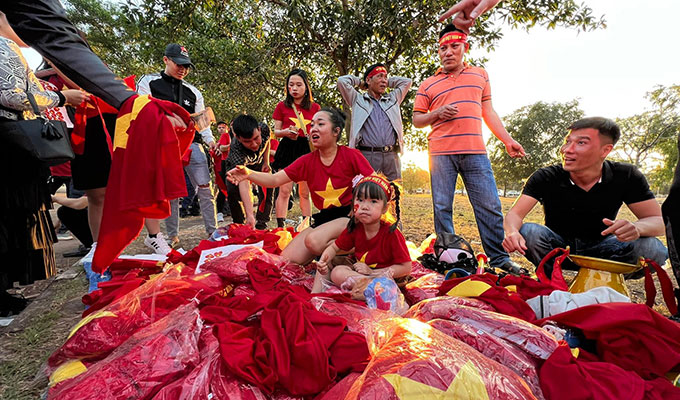 Các CĐV Việt Nam trưng bày gian hàng bán bandron, cờ đỏ sao vàng và những dụng cụ vào sân cổ vũ ngay bên ngoài cổng SVĐ QG Lào 