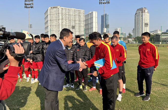 Chủ tịch Trần Quốc Tuấn bắt tay HLV Hoàng Anh Tuấn và lì xì đầu năm cho các thành viên đội tuyển - Ảnh: VFF