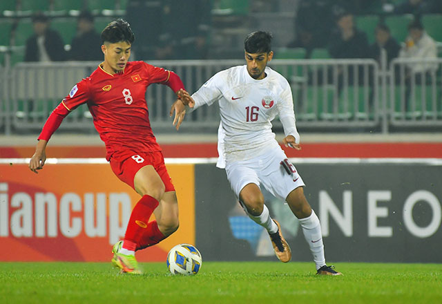 Văn Trường (trái) tự tin đi bóng trước các cầu thủ Qatar - Ảnh: Phan Hồng
