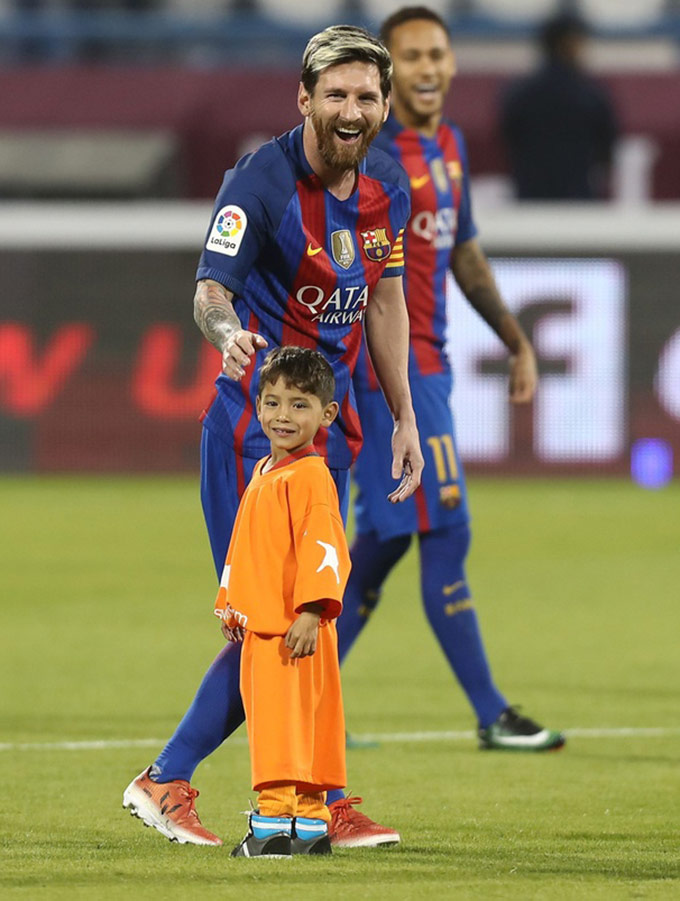 Messi dắt tay cậu bé 6 tuổi ra sân trong trận giao hữu trên sân Al-Gharrafa 