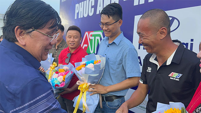 Ông Nguyễn Văn Lên tặng hoa cho Phúc "đạo diễn" và ông Thế Quang, đại diện nhãn hàng Thể thao Iwin
