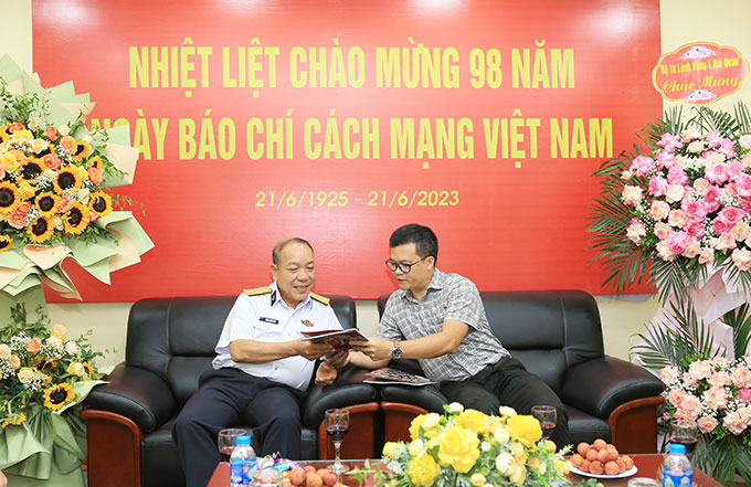 TBT Nguyễn Tùng Điển tặng ấn phẩm mới nhất của Tạp chí Bóng đá cho Chính ủy Vùng 1 Hải quân Trần Xuân Văn (bên trái)