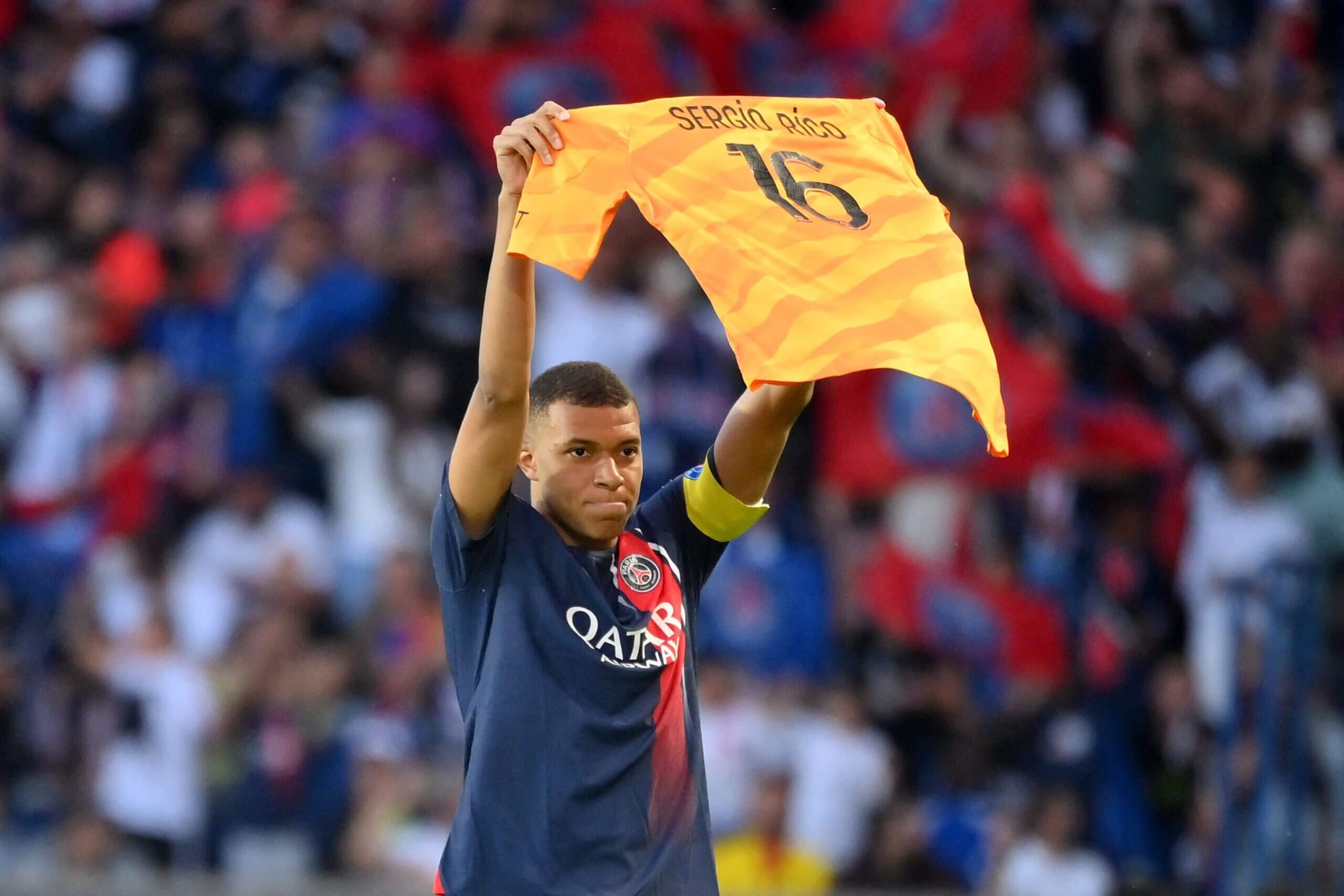 Mbappe giơ cao chiếc áo đấu của Rico để thể hiện sự ủng hộ của mình