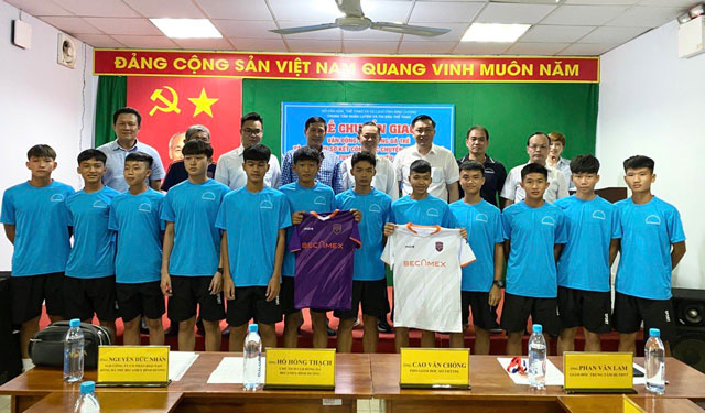 Đại biểu chụp ảnh lưu niệm cùng 12 VĐV U15 được chuyển giao cho Trung tâm Đào tạo bóng đá trẻ Becamex Bình Dương