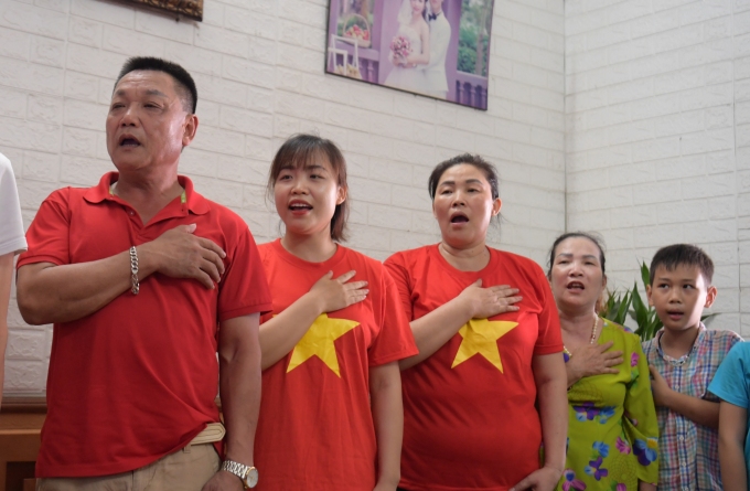 Khi quốc ca Việt Nam vang lên, gia đình Hải Linh đều đứng dậy và hát quốc ca với sự tự hào lớn. Ảnh: Giang Nguyễn