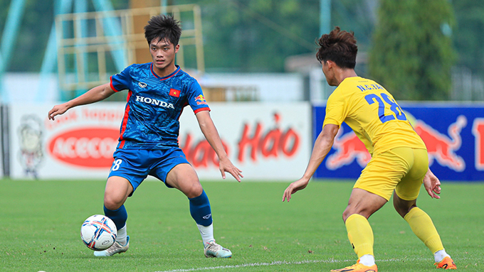 Tiền đạo Quốc Việt đi bóng trước cầu thủ của U21 Hà Nội 