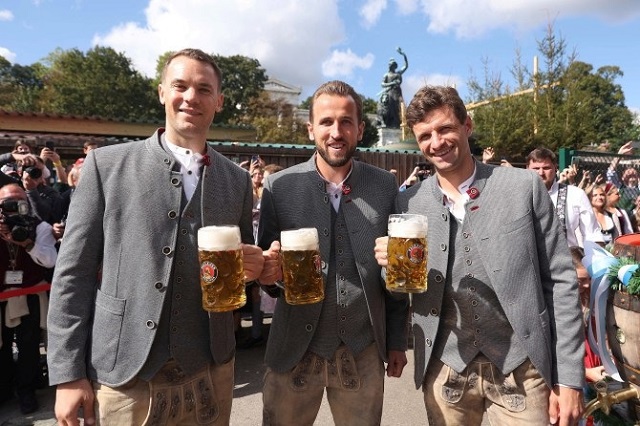 Kane nâng bia bên cạnh các đồng đội Thomas Muller và Manuel Neuer