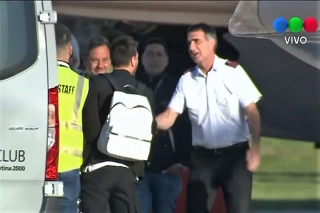 Messi bắt tay nhà báo Antonio Laje khi xuống máy bay