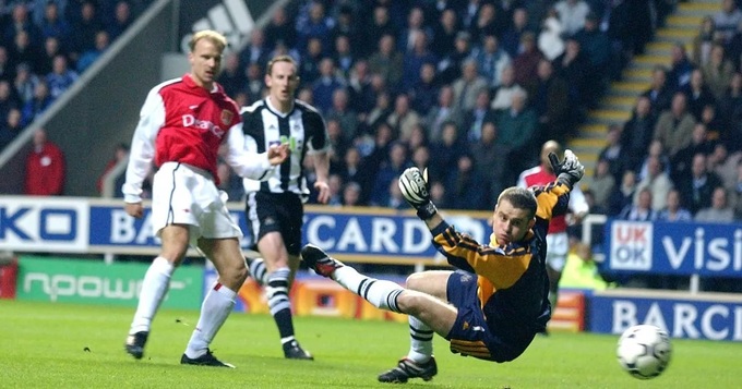 Bergkamp tung hoành trước hàng thủ Newcastle và ghi bàn thắng cho Arsenal.