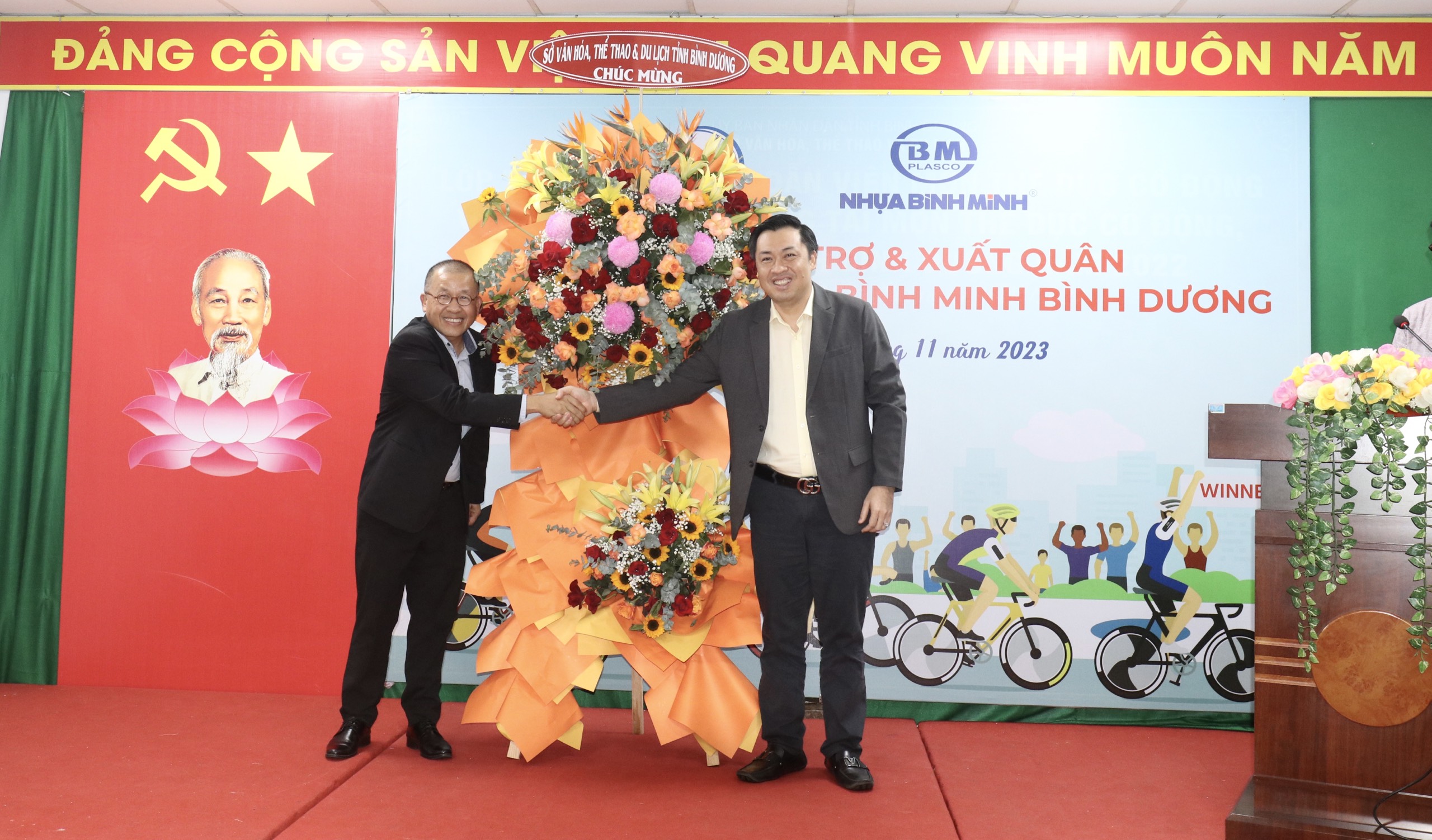 Ông Cao Văn Chóng (bên phải) – Phó Giám đốc Sở Văn hoá, Thể thao và Du lịch tỉnh Bình Dương tặng hoa cảm ơn đại diện nhà tài trợ, ông Chaowalit Treejak (bên trái) - Tổng Giám đốc Công ty Nhựa Bình Minh