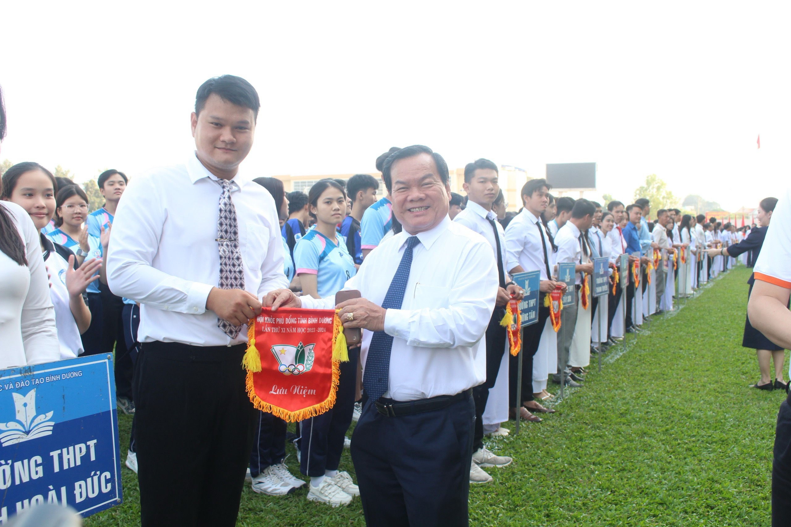 Ông Phạm Văn Bảy - PCT UBND thành phố Dĩ An trao cờ lưu niệm cho các đoàn thể thao