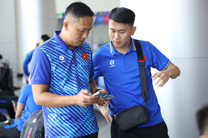 Trợ lý Huỳnh Ngọc Quốc hướng dẫn cầu thủ  đăng ký ESIM ngay tại sân bay Tân Sơn Nhất