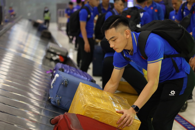 Cầu thủ Anh Duy lấy hành lý ở sân bay Bangkok