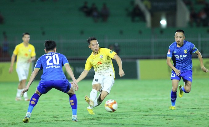 Pha tranh bóng của cầu thủ hai đội Bình Định (áo vàng) và SLNA - Ảnh: CTV