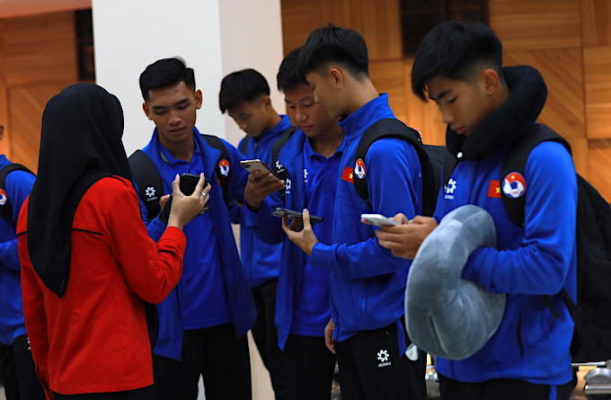 Nhân viên ở sân bay hỗ trợ các cầu thủ đăng nhập mạng internet - Ảnh: Phan Hồng
