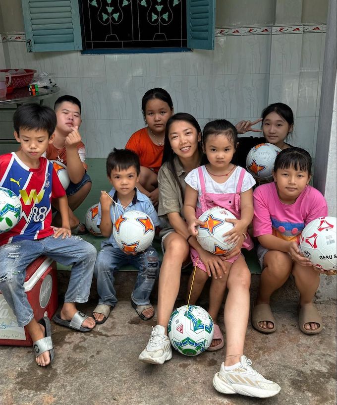 Huỳnh Như tặng bóng cho các em nhỏ ở quê nhà. Ảnh: FBNV