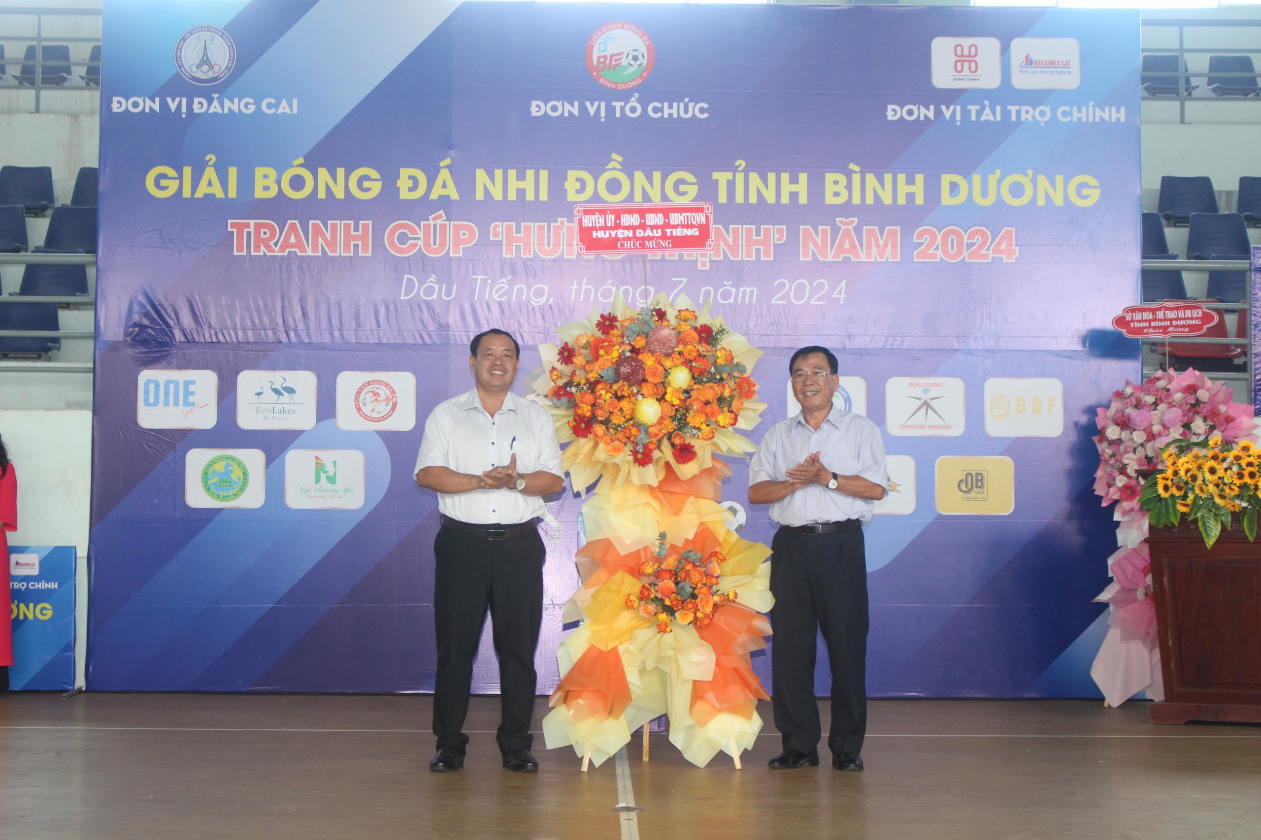 Ông Nguyễn Văn Bình - Chủ tịch UBMTTQ VN huyện Dầu Tiếng trao lẵng hoa của huyện Dầu Tiếng chúc mừng BTC giải