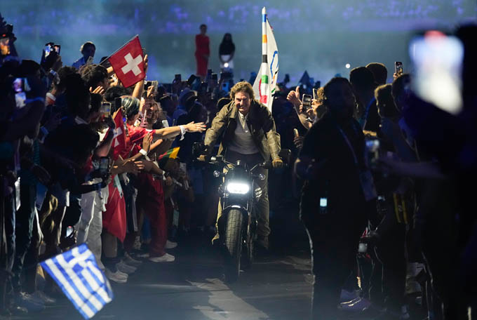 Tom Cruise nhận lá cờ Olympic và lái môtô rời khỏi sân vận động