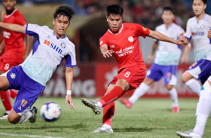 Cầu thủ SHB Đà Nẵng nỗ lực cản phá cú dứt điểm của Hữu Thắng. Ảnh: Đức Cường 