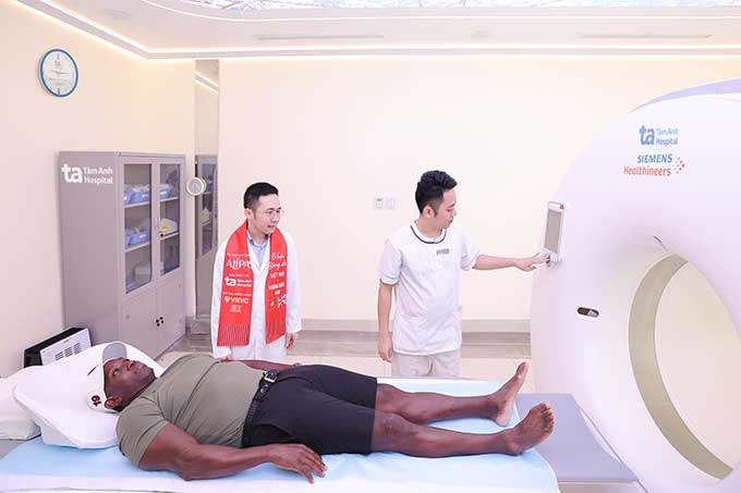 Danh thủ Dwight Yorke trải nghiệm chụp siêu máy CT Somatom Force VB30 ứng dụng AI đầu tiên tại Việt Nam để tầm soát các chấn thương tiềm ẩn. Ảnh: BVĐK Tâm Anh 