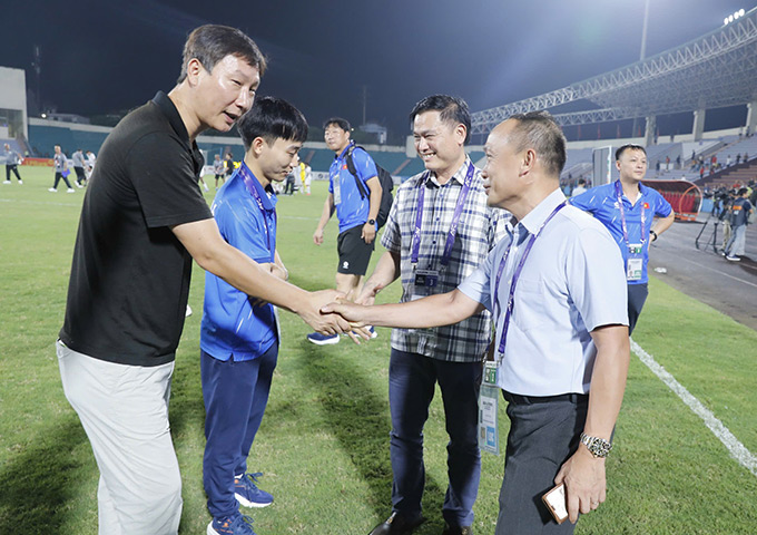 Đại diện lãnh đạo VFF chúc mừng HLV Kim Sang Sik - Ảnh: Đức Cường