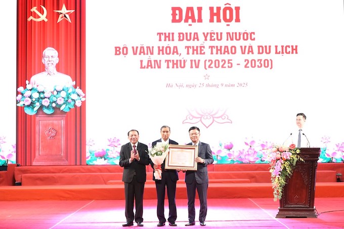 HLV Mai Đức Chung vinh dự nhận danh hiệu Anh hùng Lao động từ Phó Thủ tướng Lê Thành Long và Bộ trưởng Bộ VH-TT-DL Nguyễn Văn Hùng. Ảnh: VFF